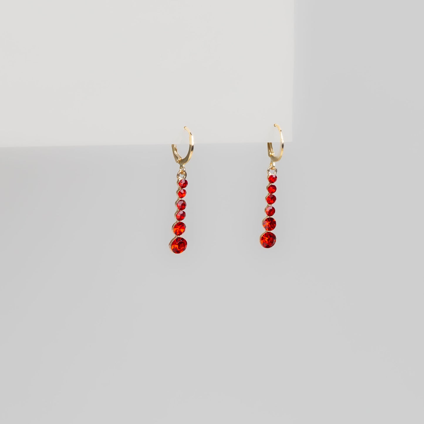Cercei aurii cu pietre roșii strălucitoare